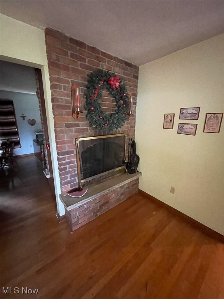 5990 Meese Road Northeast Louisville, OH 44641 - Photo 13 of 16 Living room with a brick fireplace and dark wood finished floors