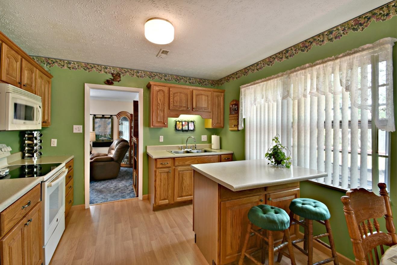 6100 McNeely Road Corryton, TN 37721 - Photo 7 of 17 a kitchen with stainless steel appliances granite countertop a stove a sink dishwasher and a refrigerator with wooden floor