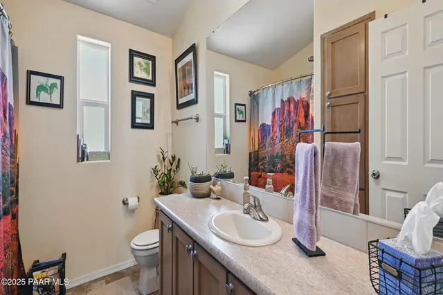a bathroom with a granite countertop sink mirror vanity and toilet