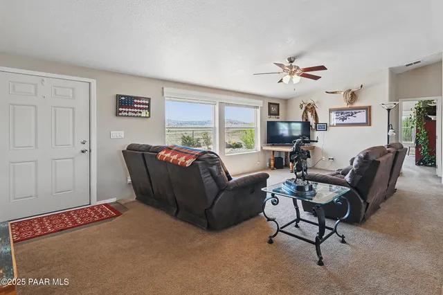 a living room with furniture a ceiling fan and a window