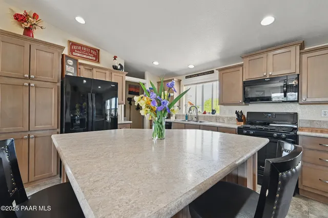 a kitchen with stainless steel appliances granite countertop a sink a stove and a refrigerator