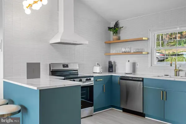 a kitchen with stainless steel appliances a sink a stove and cabinets