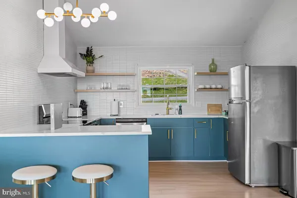 a kitchen with stainless steel appliances granite countertop a sink a stove and a refrigerator