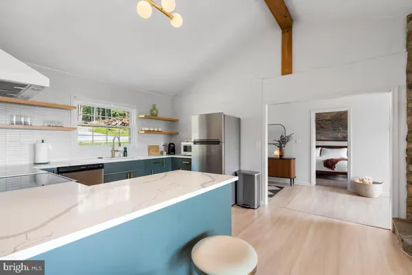 a kitchen with stainless steel appliances kitchen island granite countertop a refrigerator and a sink