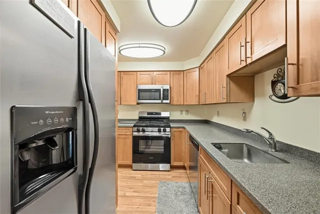 a kitchen with stainless steel appliances granite countertop a sink a stove a microwave oven with cabinets