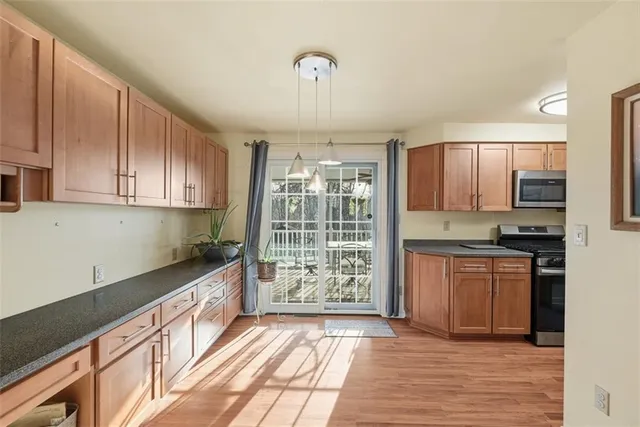 a kitchen with granite countertop a stove top oven cabinetry a chimney and cabinets