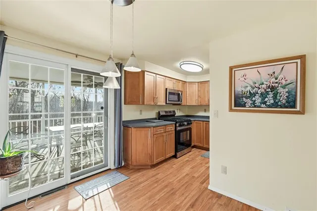 a kitchen with stainless steel appliances granite countertop a refrigerator a stove a sink and a dishwasher with wooden floor