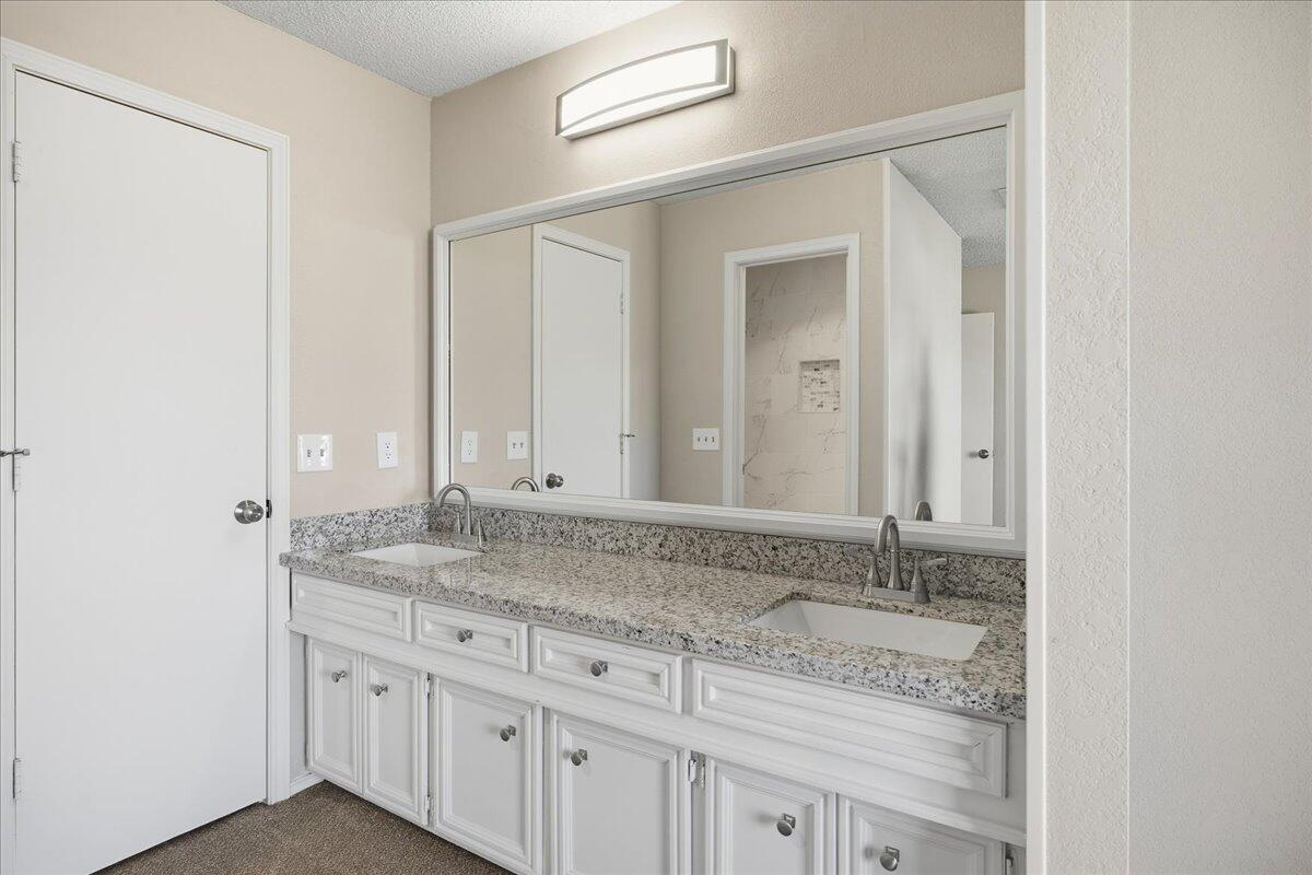 2301 92nd Street Lubbock, TX 79423 - Photo 16 of 30 a bathroom with a granite countertop sink and a mirror