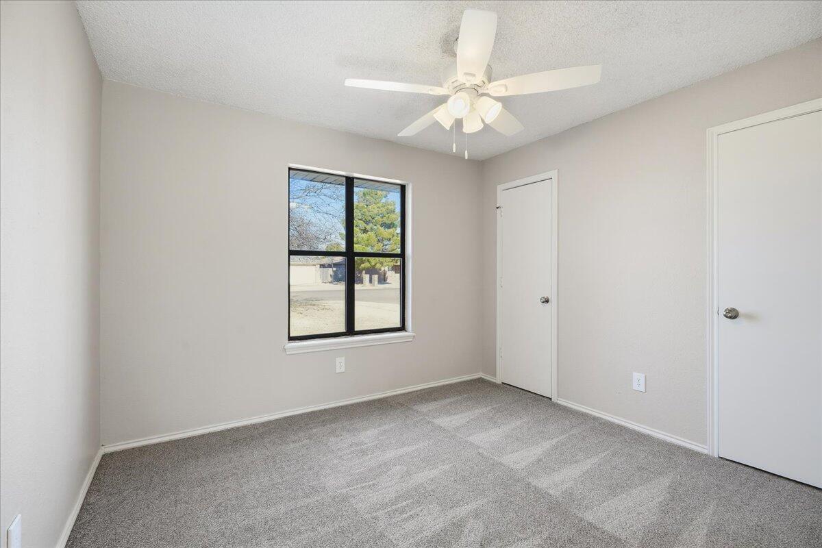 2301 92nd Street Lubbock, TX 79423 - Photo 19 of 30 an empty room with windows and fan