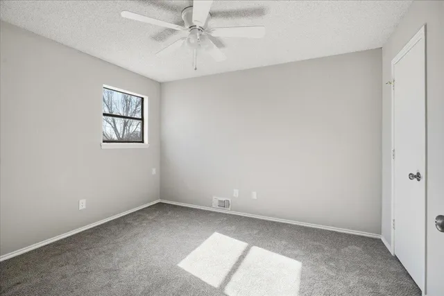 a view of an empty room with closet and a window