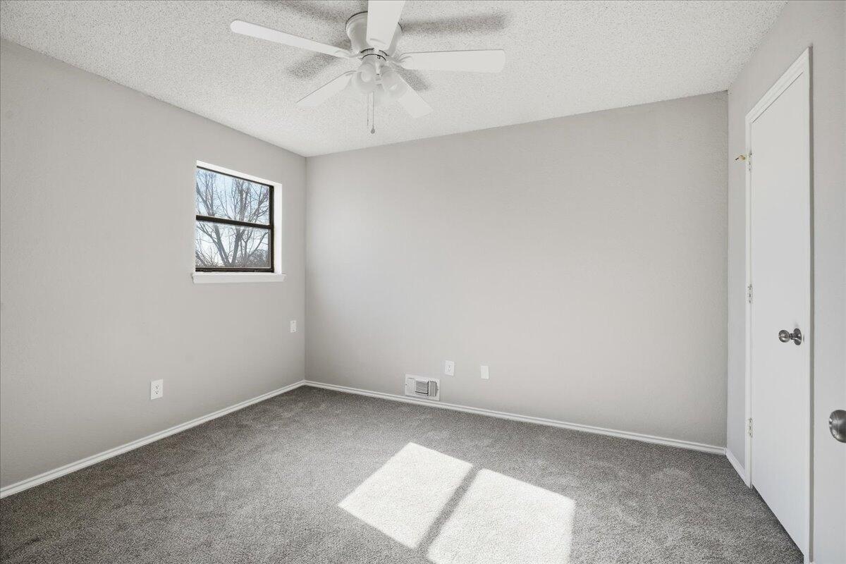2301 92nd Street Lubbock, TX 79423 - Photo 25 of 30 an empty room with a window and a fan