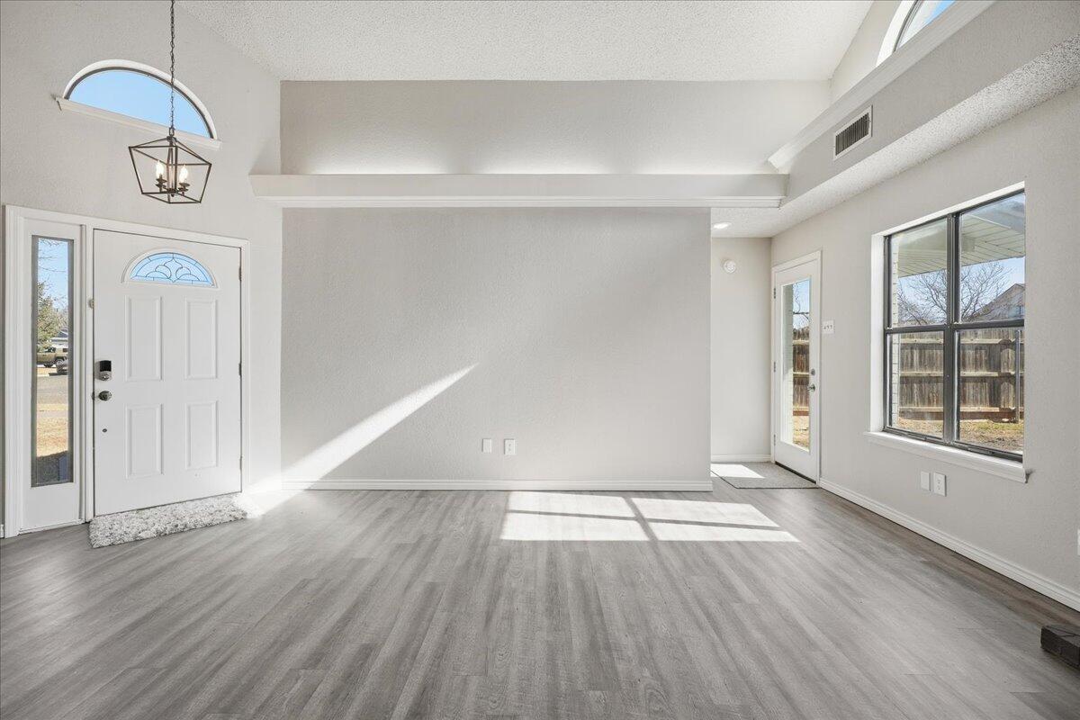 2301 92nd Street Lubbock, TX 79423 - Photo 4 of 30 a view of an empty room with wooden floor and a window