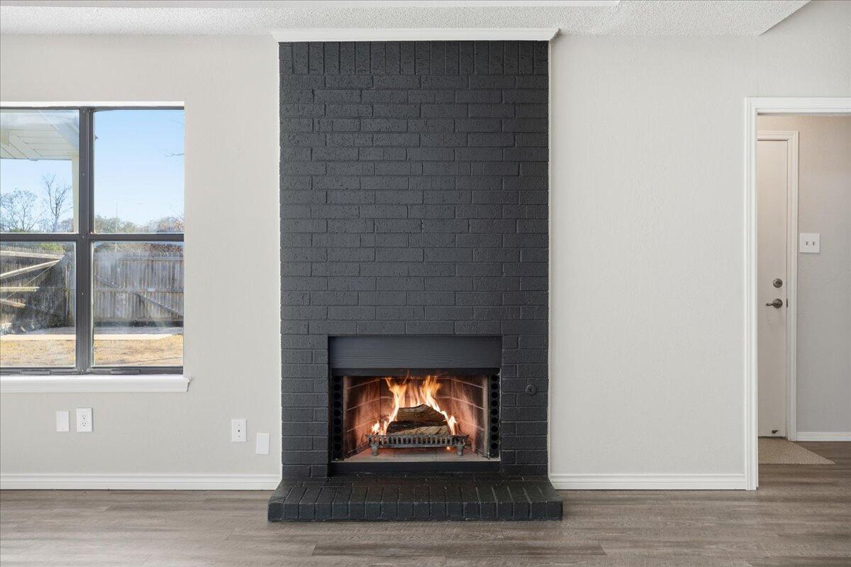2301 92nd Street Lubbock, TX 79423 - Photo 6 of 30 a living room with a fireplace and a window