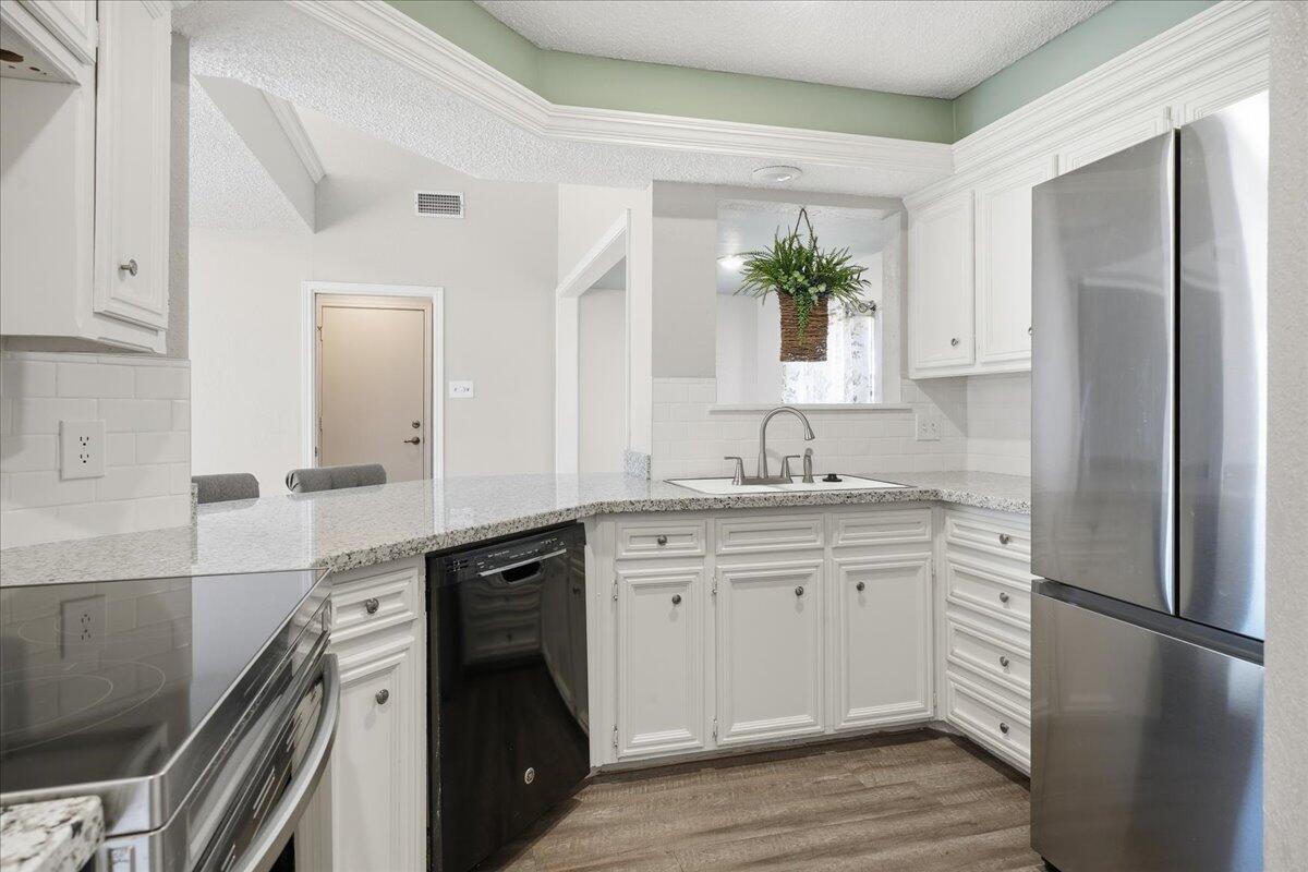 2301 92nd Street Lubbock, TX 79423 - Photo 9 of 30 a kitchen with a refrigerator and a sink