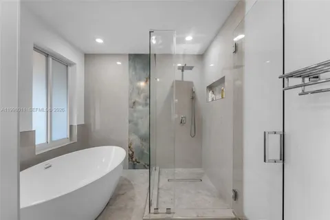 a bathroom with a bathtub a shower and a sink