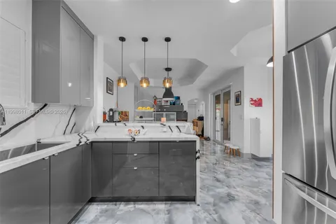 a kitchen with stainless steel appliances granite countertop a sink and a refrigerator