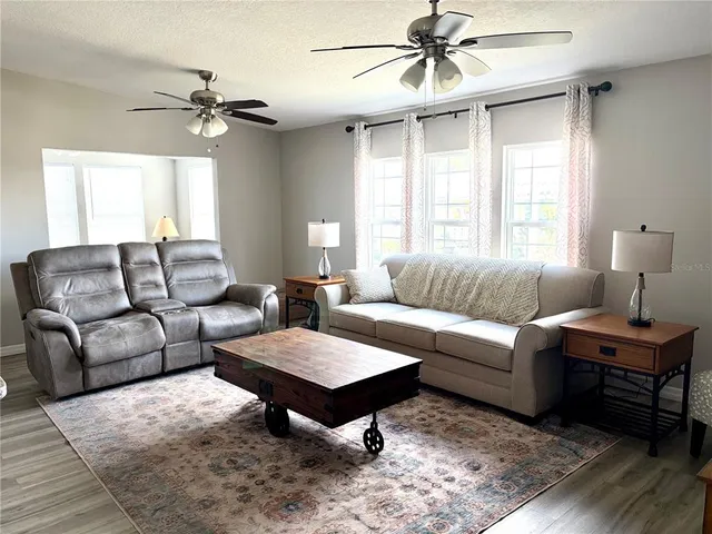 a living room with furniture a chandelier and a window