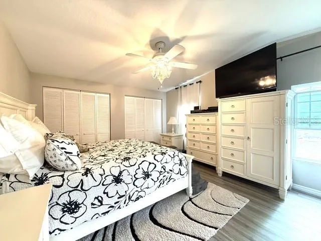 a bedroom with a bed and a flat tv screen on dresser