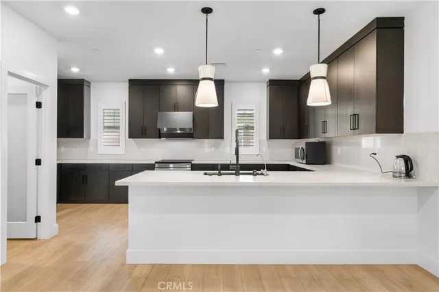 a large kitchen with granite countertop a stove a sink and a microwave