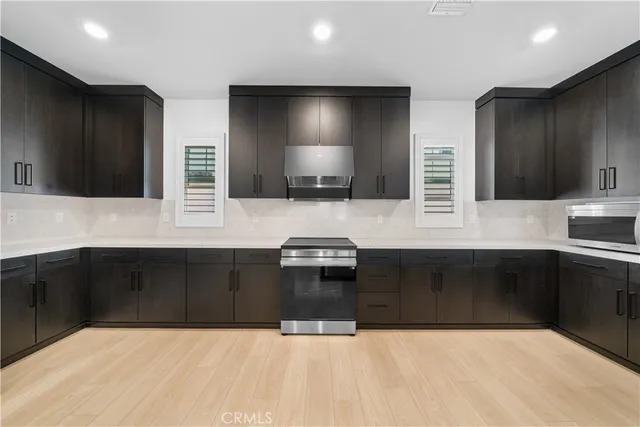 a large kitchen with kitchen island a sink stainless steel appliances and a chandelier