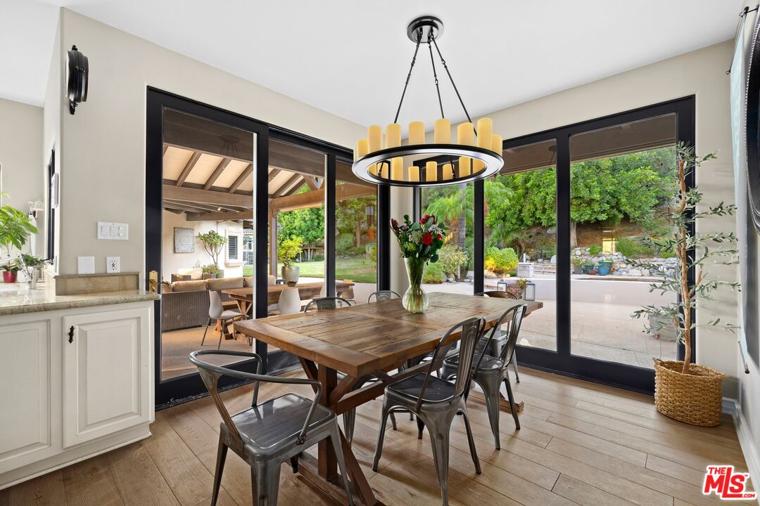 25217 Eldorado Meadow Road Hidden Hills, CA 91302 - Photo 10 of 26 a dining room with furniture wooden floor a chandelier and a rug