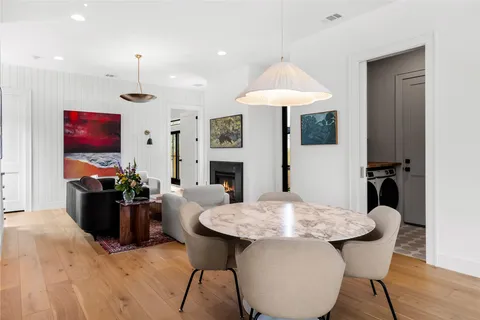 a view of a dining room with furniture a fireplace and wooden floor