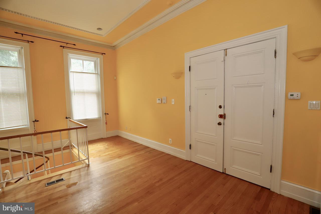 1737 Wallace Street, Unit 101 Philadelphia, PA 19130 - Photo 6 of 15 an empty room with wooden floor and windows