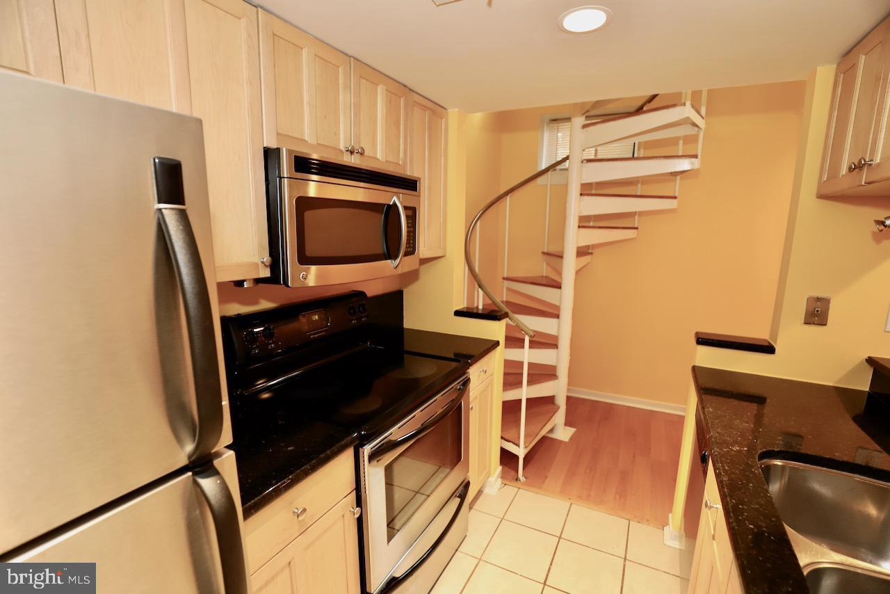 1737 Wallace Street, Unit 101 Philadelphia, PA 19130 - Photo 10 of 15 a kitchen with stainless steel appliances a stove top oven and a refrigerator