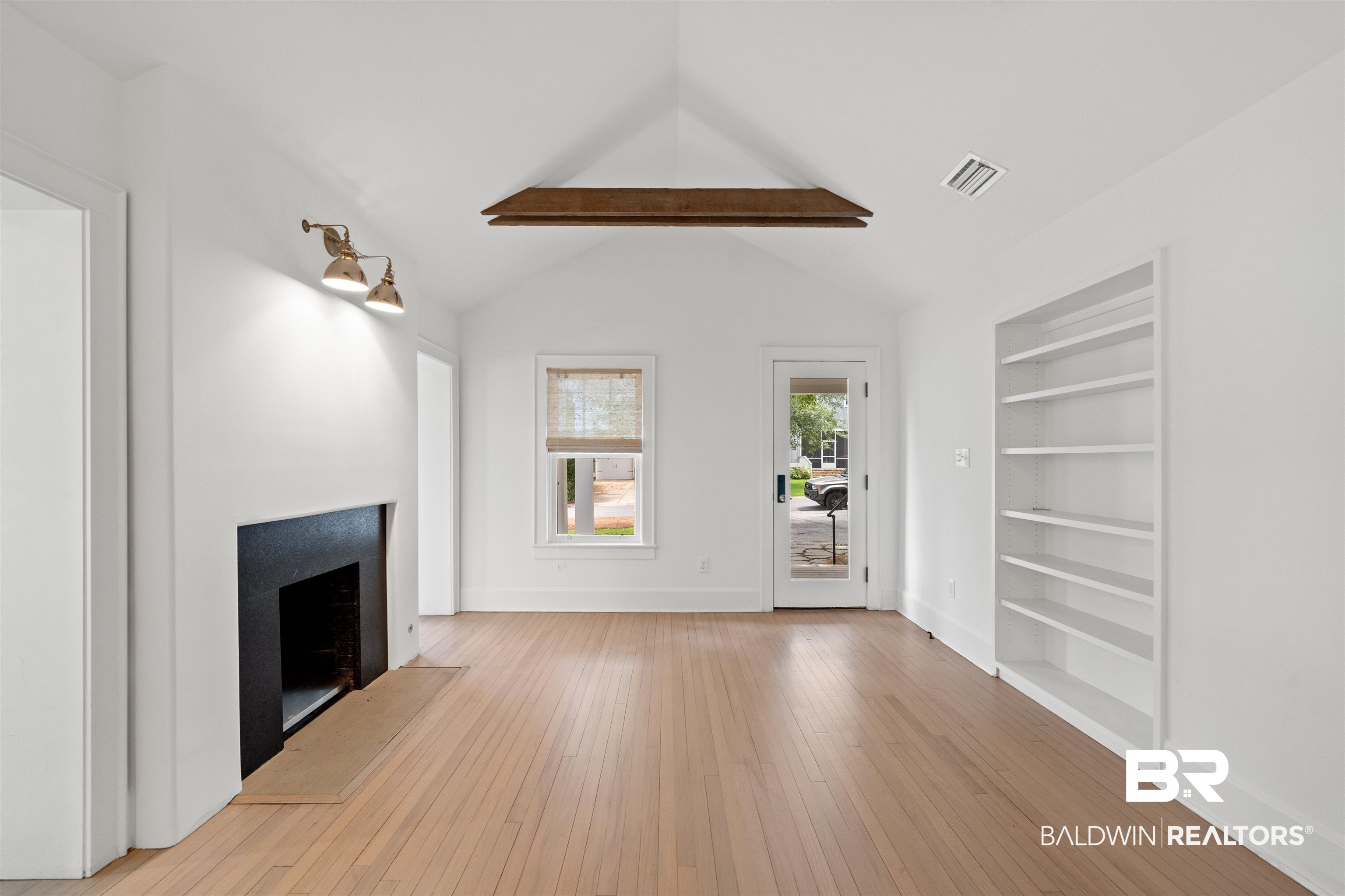 106 White Avenue Fairhope, AL 36532 - Photo 3 of 35 Unfurnished living room with a fireplace, built in shelves, and light wood-style floors