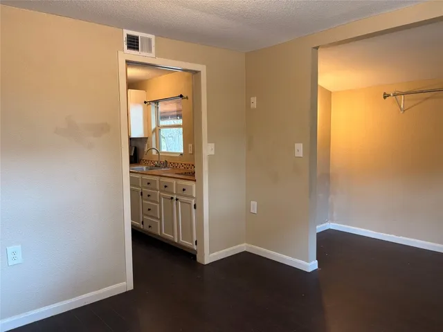 a view of a hallway with closet and wooden floor