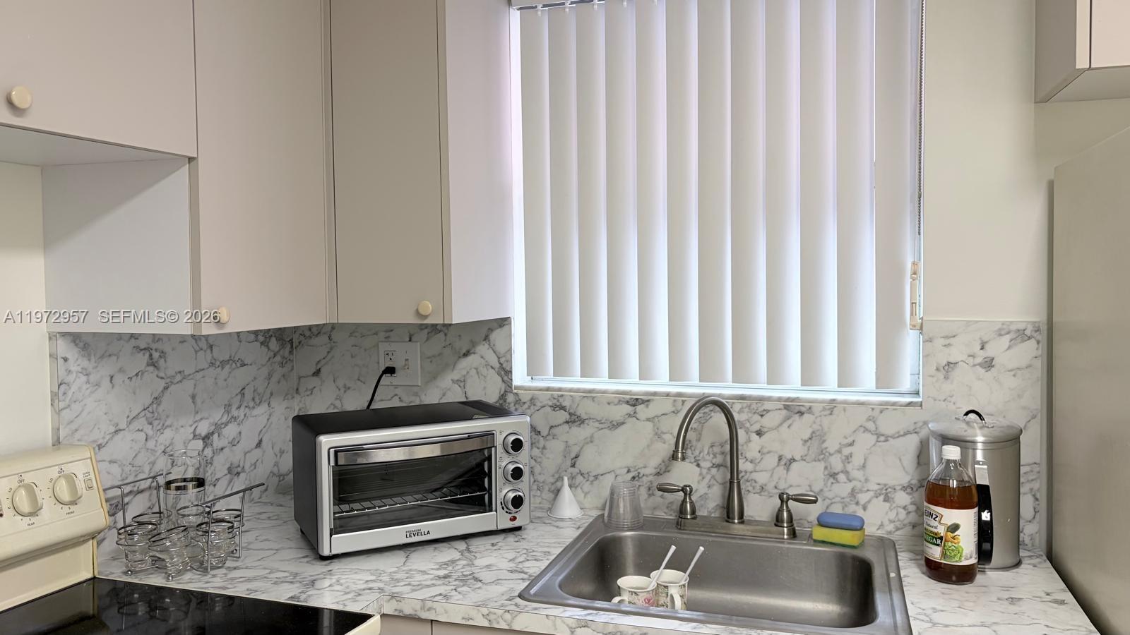 199 Southwest 12th Avenue, Unit 415B Miami, FL 33130 - Photo 19 of 39 a kitchen with a sink and a stove top oven