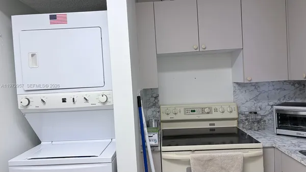 a kitchen with a stove and white cabinets