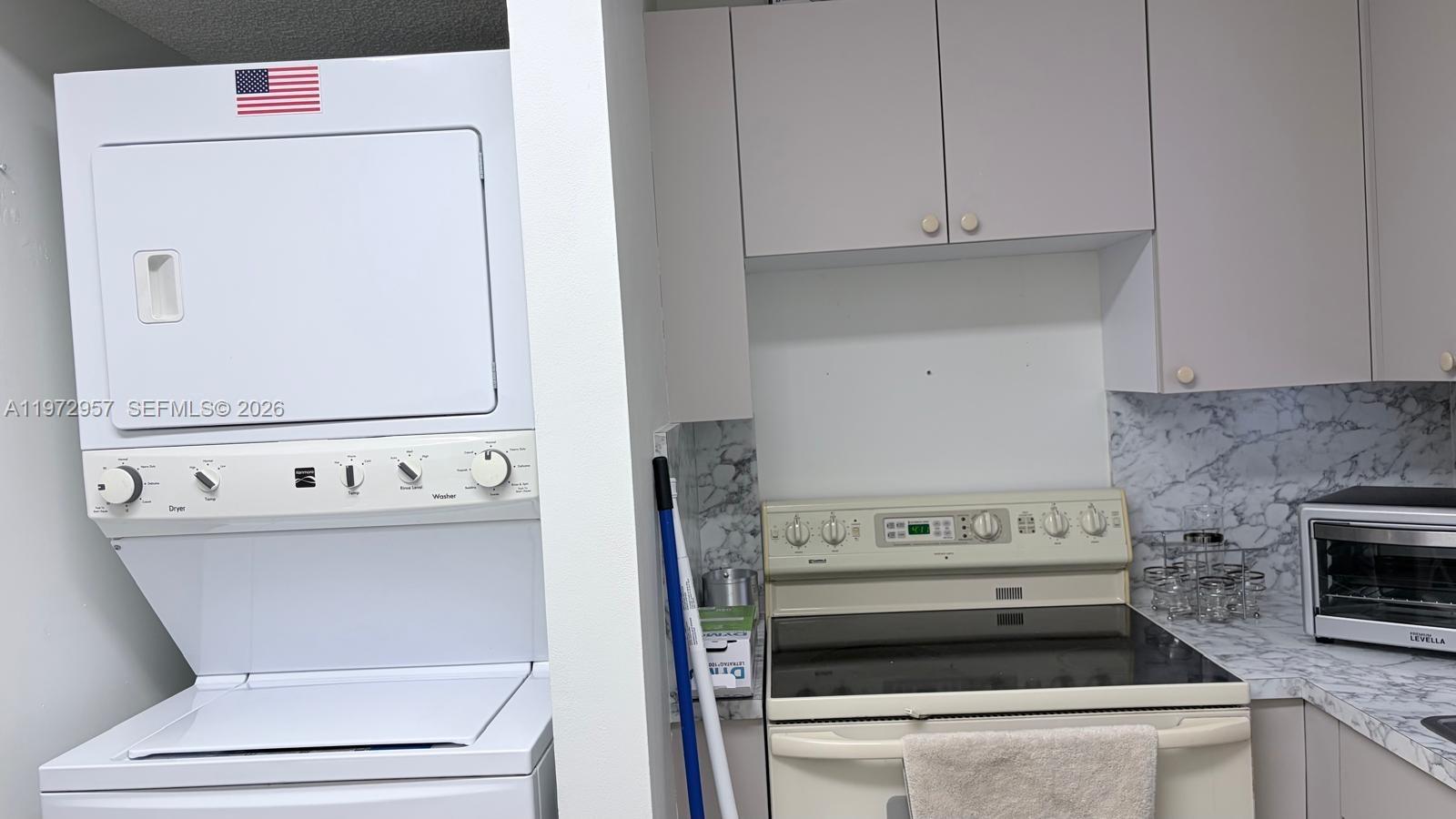 199 Southwest 12th Avenue, Unit 415B Miami, FL 33130 - Photo 21 of 39 a kitchen with a stove and white cabinets