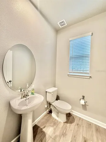a bathroom with a toilet sink and mirror