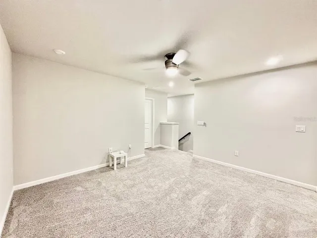 an empty room with a ceiling fan and window