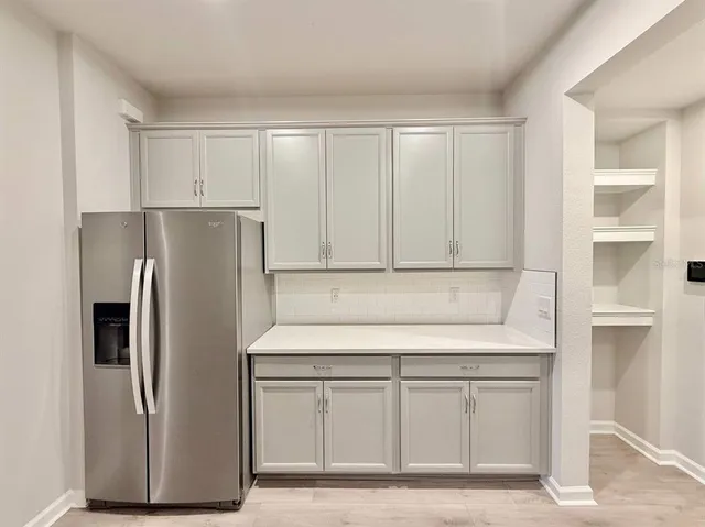 a kitchen with a refrigerator sink and cabinets