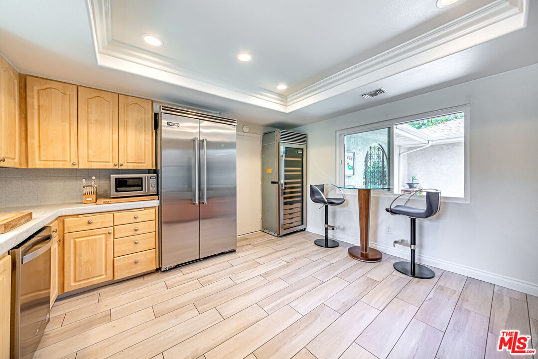 1195 Vía Pintada Riverside, CA 92507 - Photo 13 of 51 a kitchen with stainless steel appliances kitchen island granite countertop a refrigerator and wooden cabinets