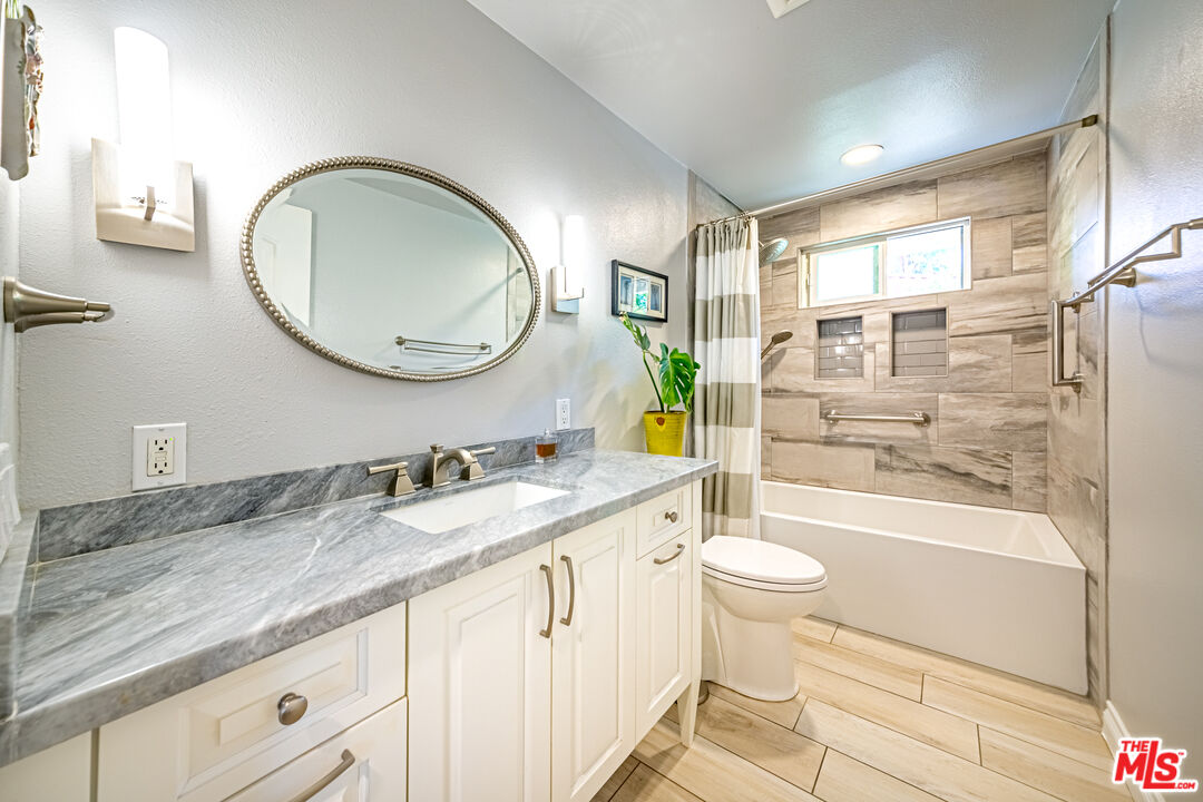 1195 Vía Pintada Riverside, CA 92507 - Photo 18 of 51 a bathroom with a granite countertop sink toilet mirror vanity and shower