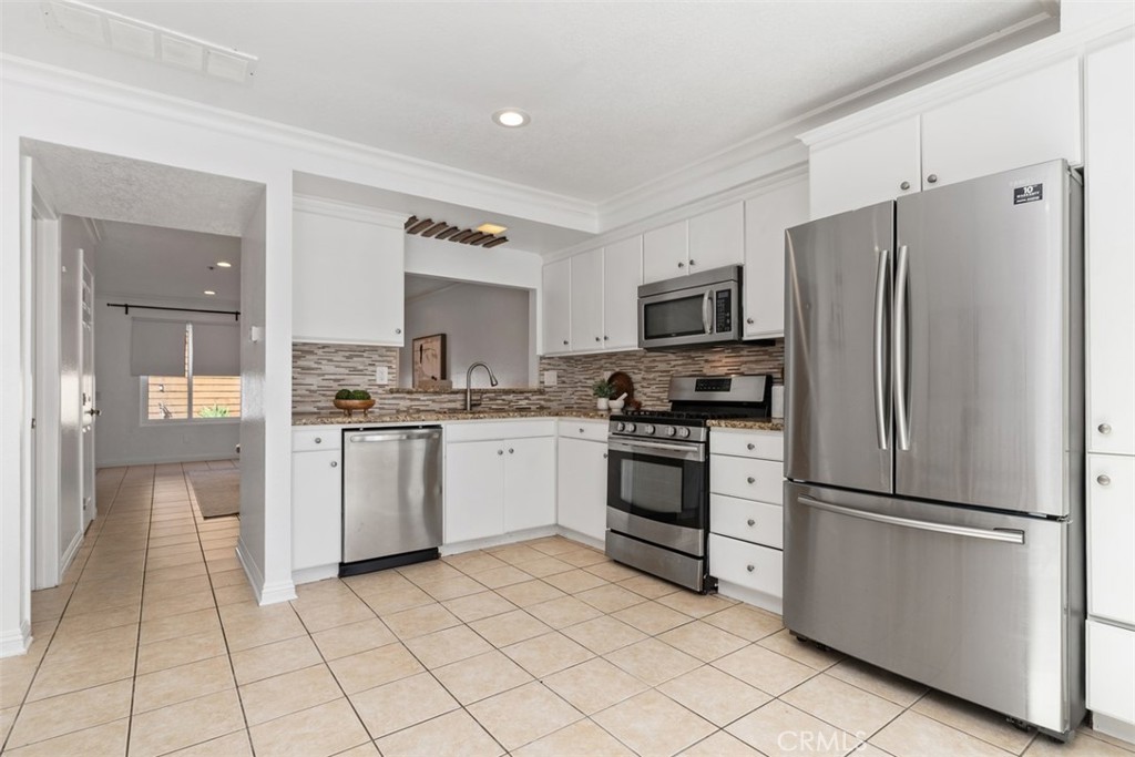 25885 Trabuco Road, Unit 203 Lake Forest, CA 92630 - Photo 11 of 43 a kitchen with white cabinets and stainless steel appliances
