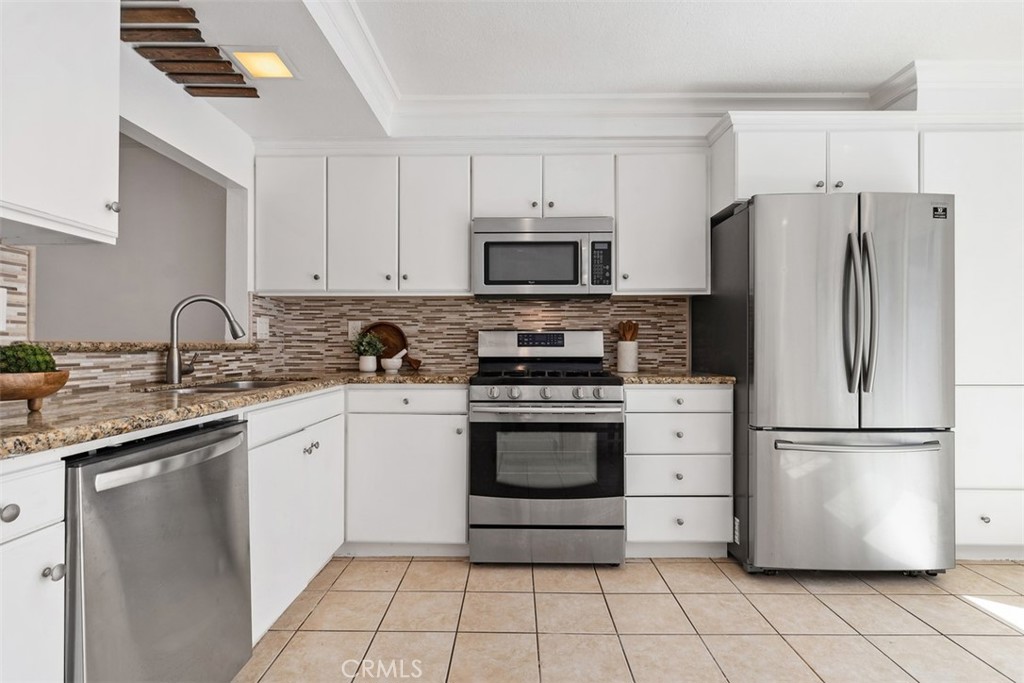 25885 Trabuco Road, Unit 203 Lake Forest, CA 92630 - Photo 12 of 43 a kitchen with a refrigerator sink and white cabinets