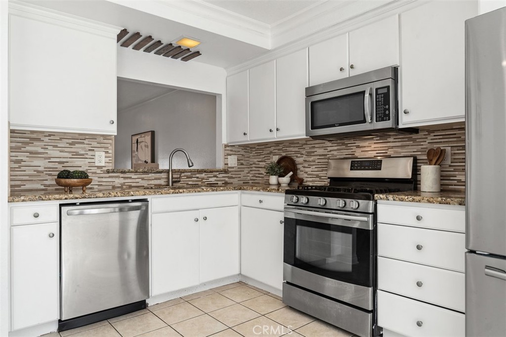 25885 Trabuco Road, Unit 203 Lake Forest, CA 92630 - Photo 2 of 43 a kitchen with white cabinets and stainless steel appliances