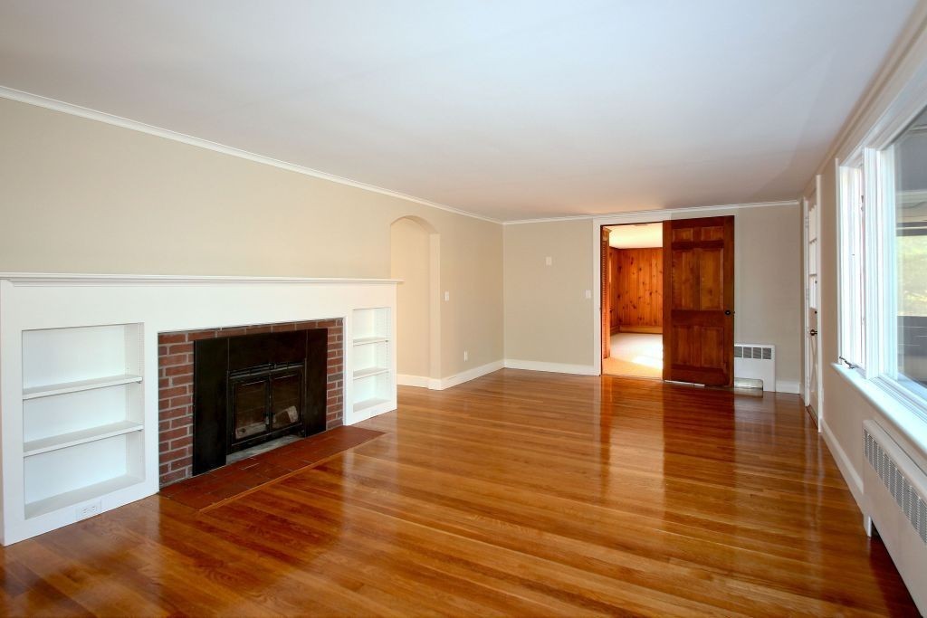 18 Parmenter Road Wayland, MA 01778 - Photo 4 of 28 an empty room with wooden floor fireplace and windows