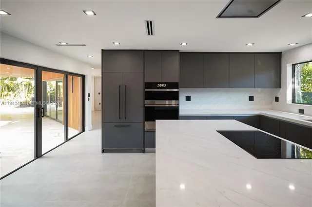 a large kitchen with stainless steel appliances lots of counter space and a sink