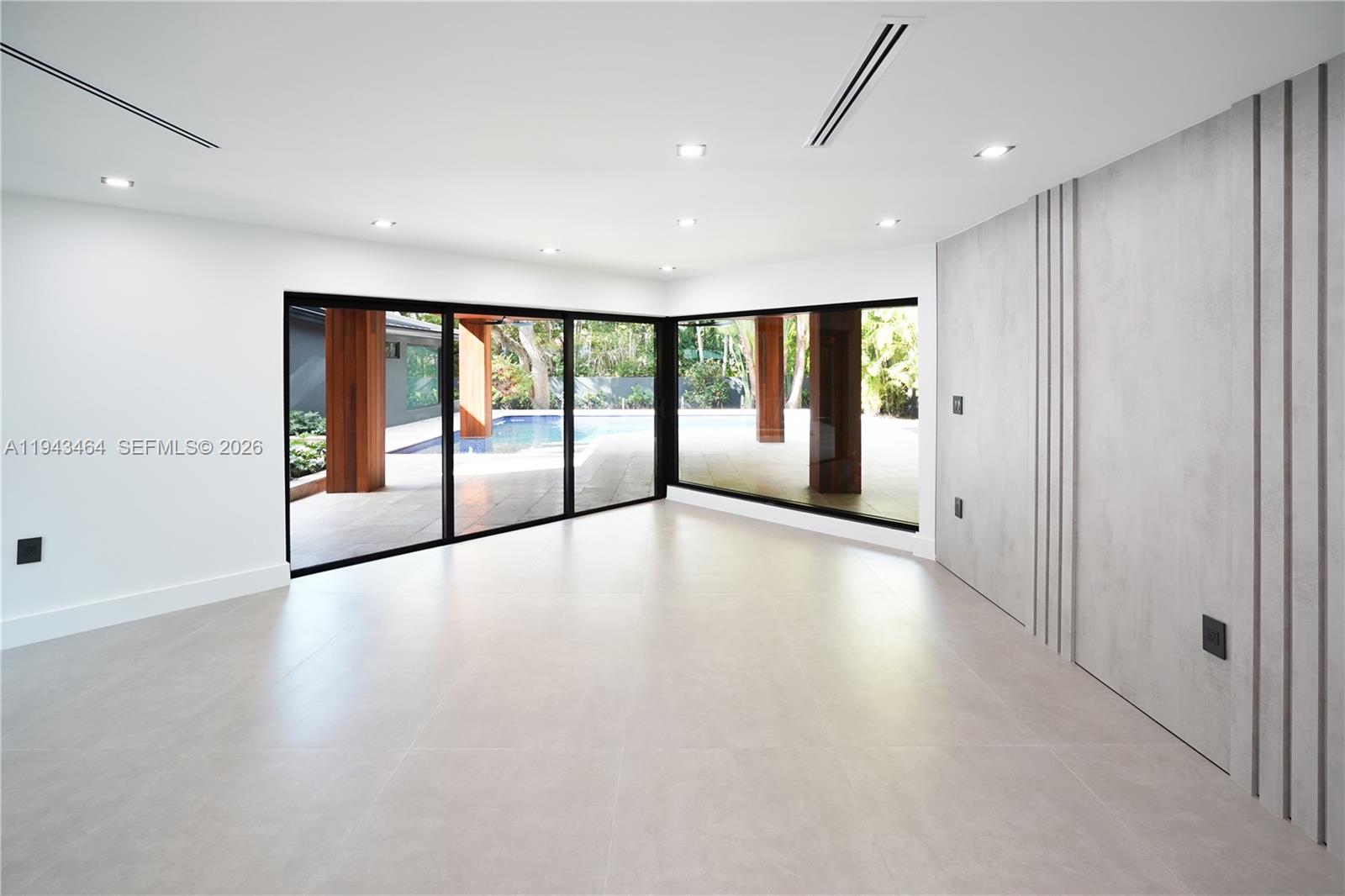 7765 Southwest 57th Terrace Miami, FL 33143 - Photo 25 of 52 an empty room with floor to ceiling windows and painted walls