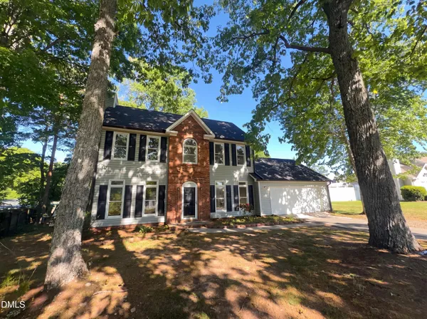 a front view of a house with a yard and tree s