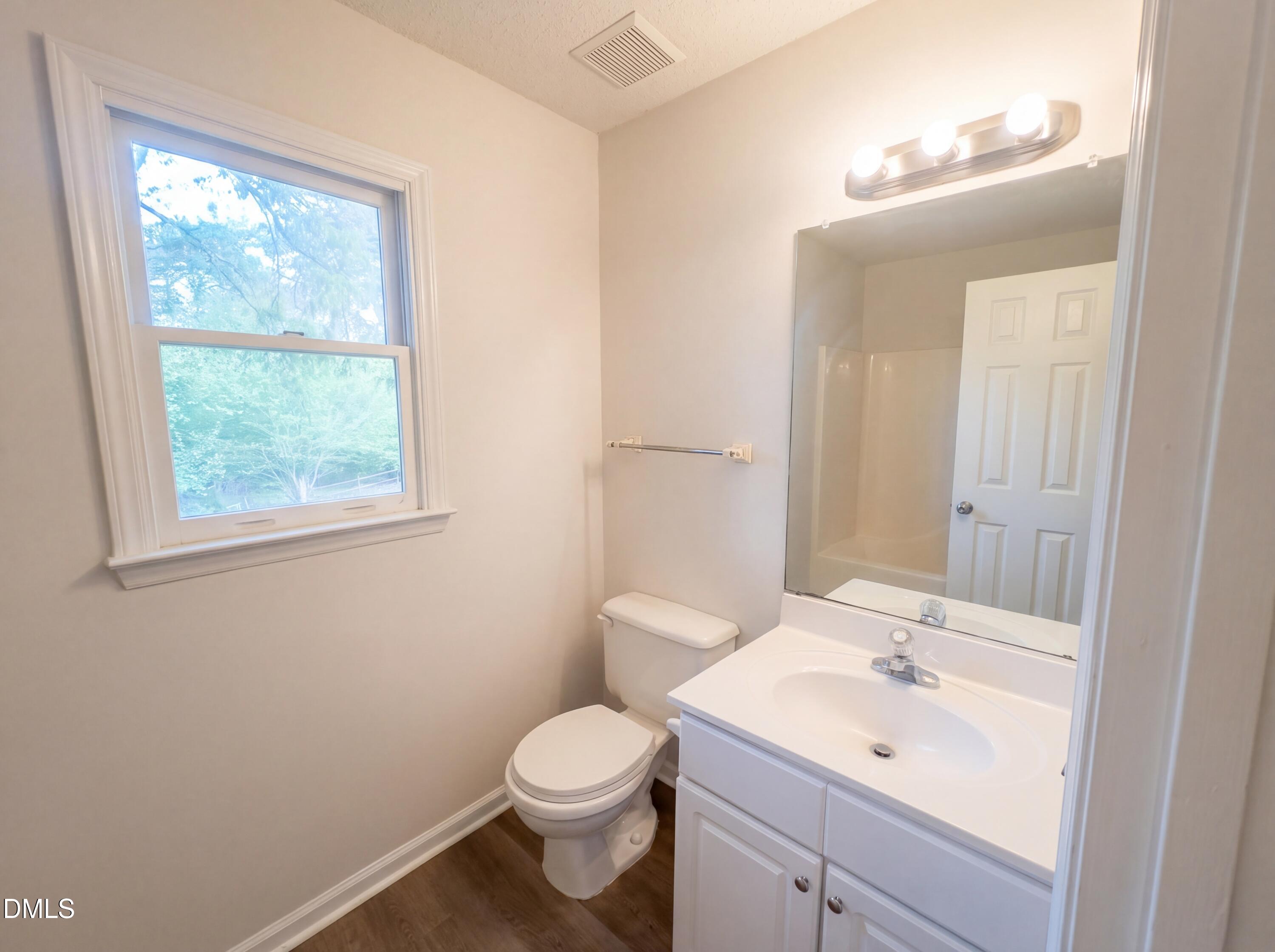 8988 Stamford Club Court Rural Hall, NC 27045 - Photo 17 of 22 a bathroom with a toilet a sink a mirror and a window
