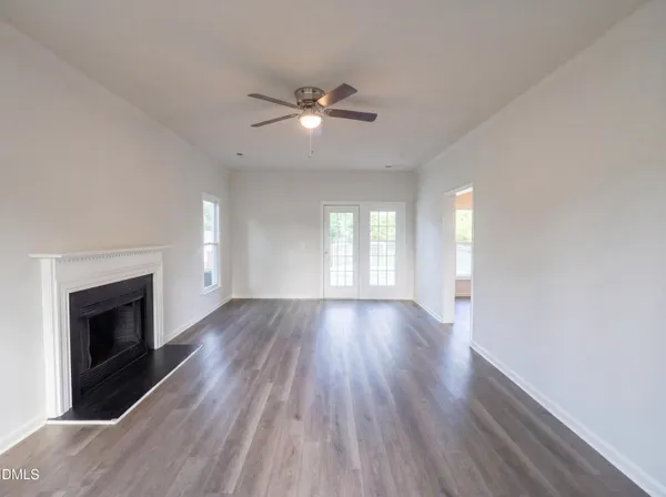 a view of empty room with wooden floor and fireplace