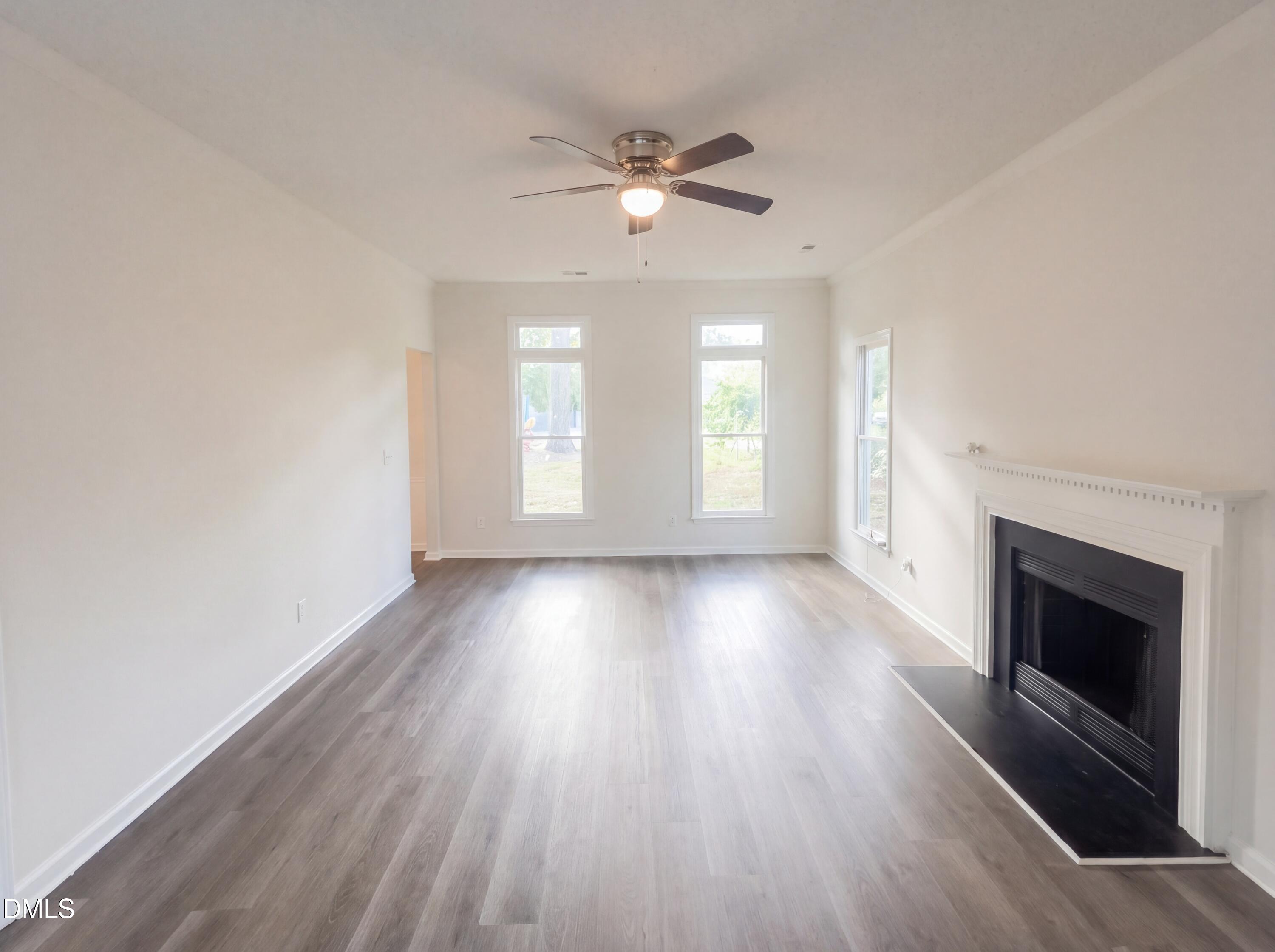 8988 Stamford Club Court Rural Hall, NC 27045 - Photo 5 of 22 an empty room with wooden floor fireplace and windows