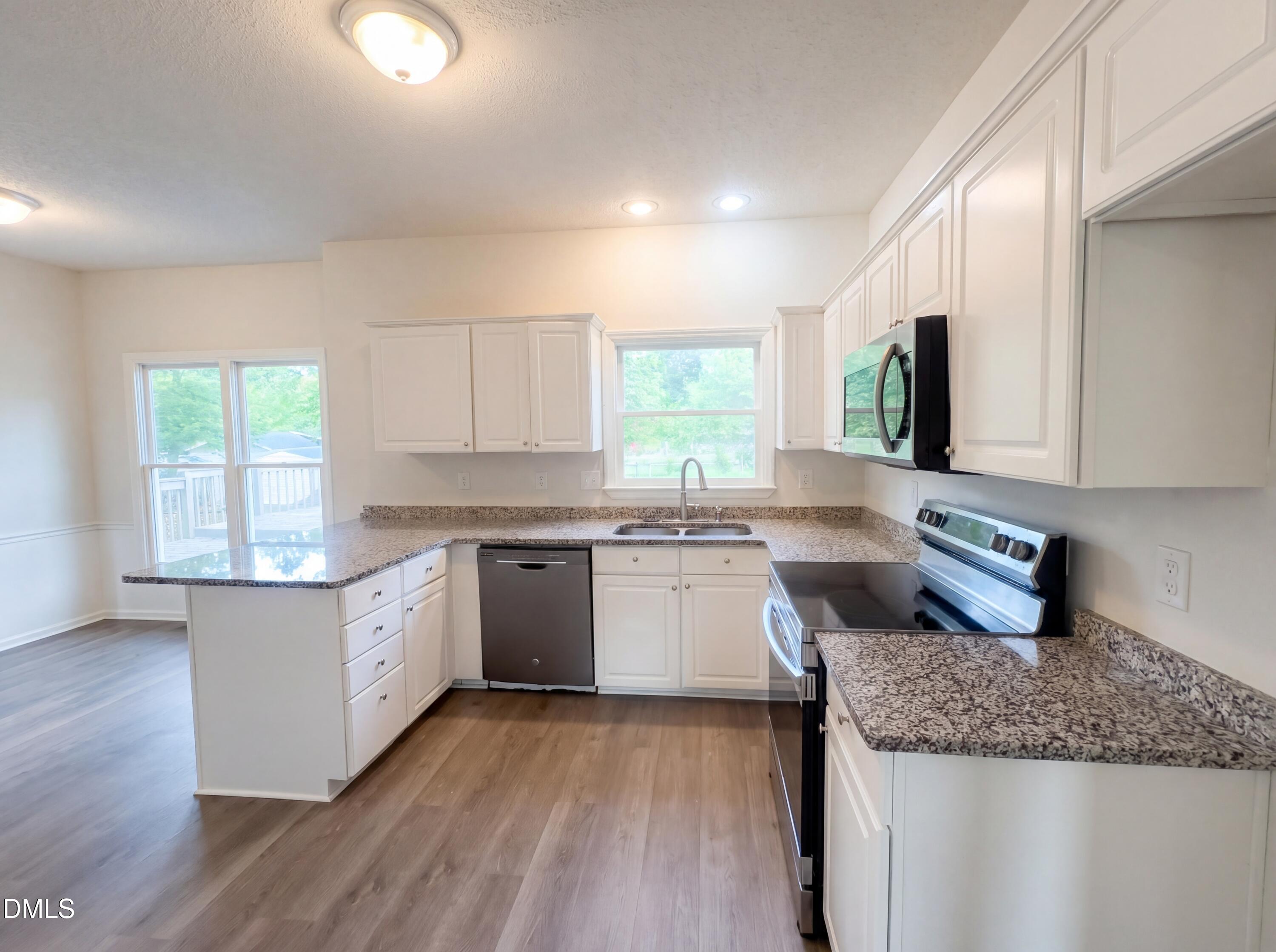 8988 Stamford Club Court Rural Hall, NC 27045 - Photo 6 of 22 a kitchen with granite countertop white cabinets and white appliances