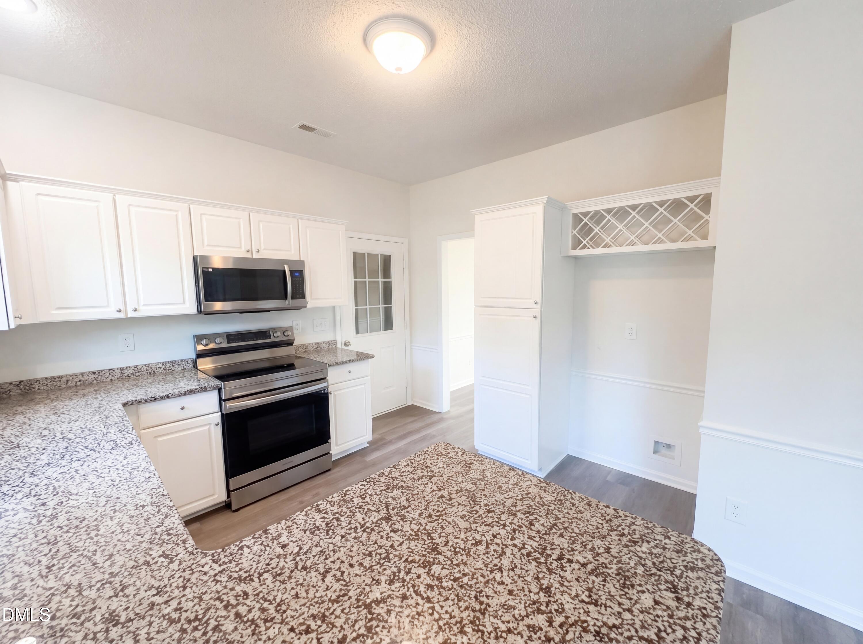 8988 Stamford Club Court Rural Hall, NC 27045 - Photo 7 of 22 a kitchen with stainless steel appliances granite countertop a stove a microwave and a refrigerator
